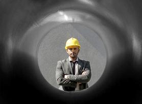 Man looking through pipe